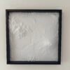 Front view of a white four-tile volcanic terrain map mounted in a deep black frame