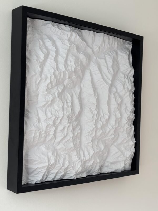 Angled view of a white four-tile terrain map mounted in a deep black frame